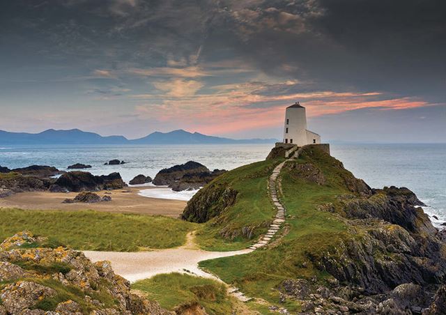 Lighthouse on a hill at sunset